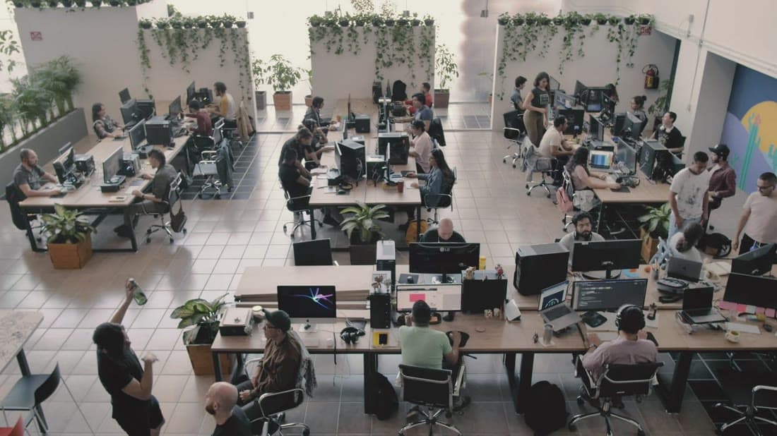 Modern open-plan technology office with teams at work