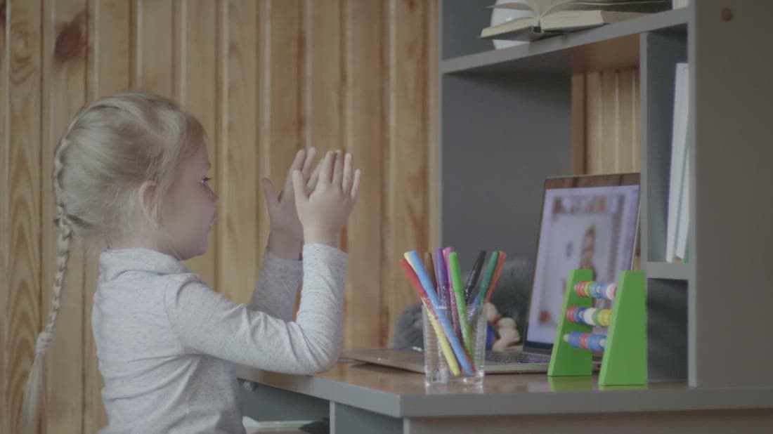Young student attending an interactive online class at home