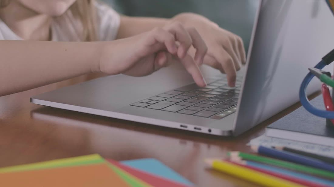 Student typing on a laptop while completing an e-learning course