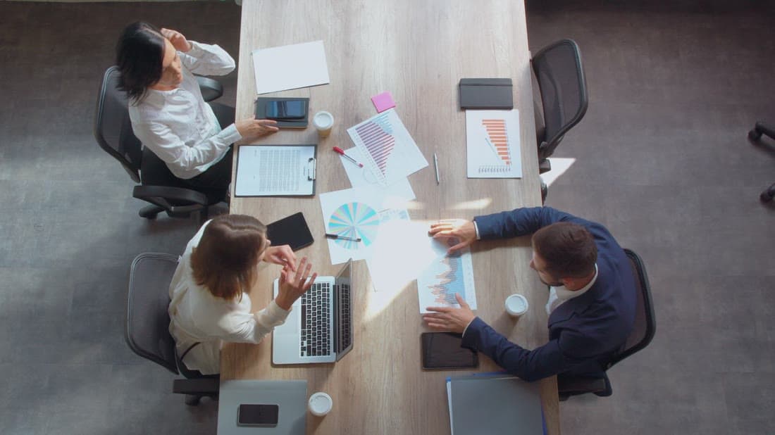 Business team reviewing ERP reports and plans around a meeting table