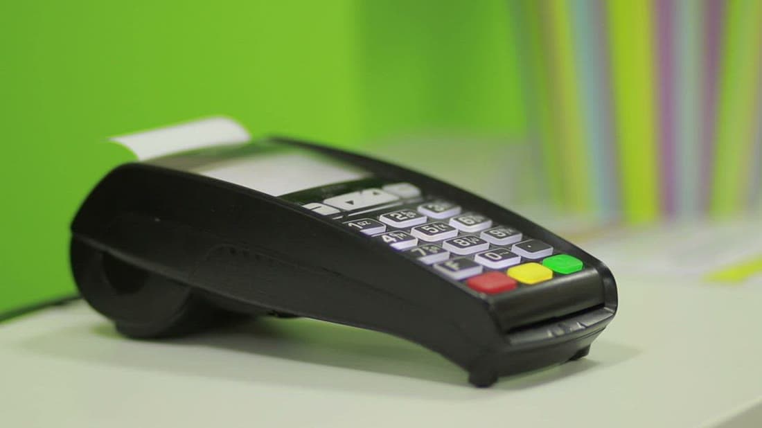 Customer completing a secure card payment while reviewing financial reports