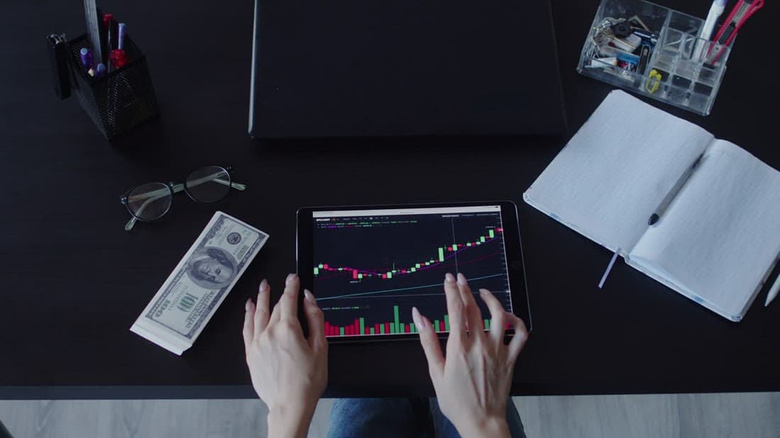 Investor reviewing portfolio performance and stock charts on a tablet