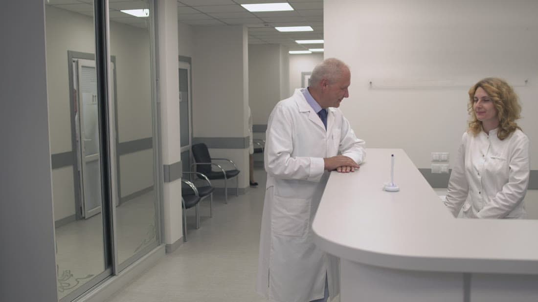 Clinic reception team assisting a patient